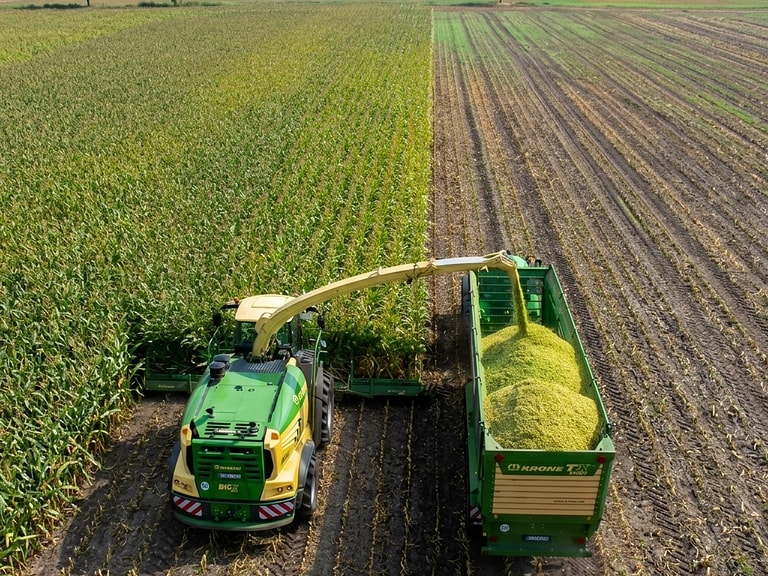 Vue aérienne de parcelles cultivées et de matériel de récolte mécanisé